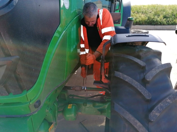 Technician adjusting the track width on a John Deere tractor | Bush Tyres