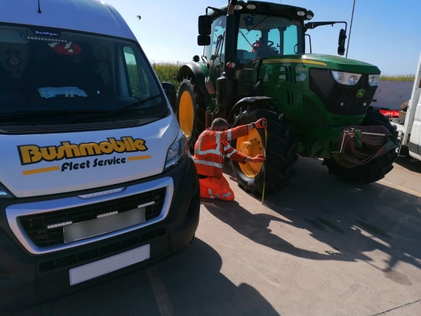 Bushmobile tecnician taking wheel measurement prior to doing a tractor wheel alignment